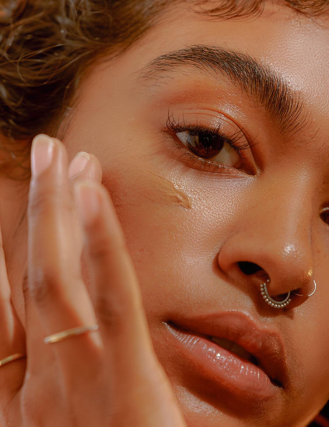 Closeup of a Young Confident Woman Applying Foundation Desktop