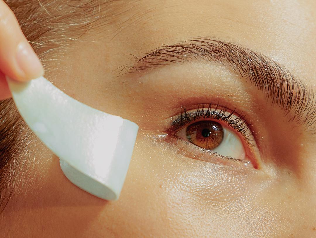 Close-up image of a model removing an under-eye mask Desktop