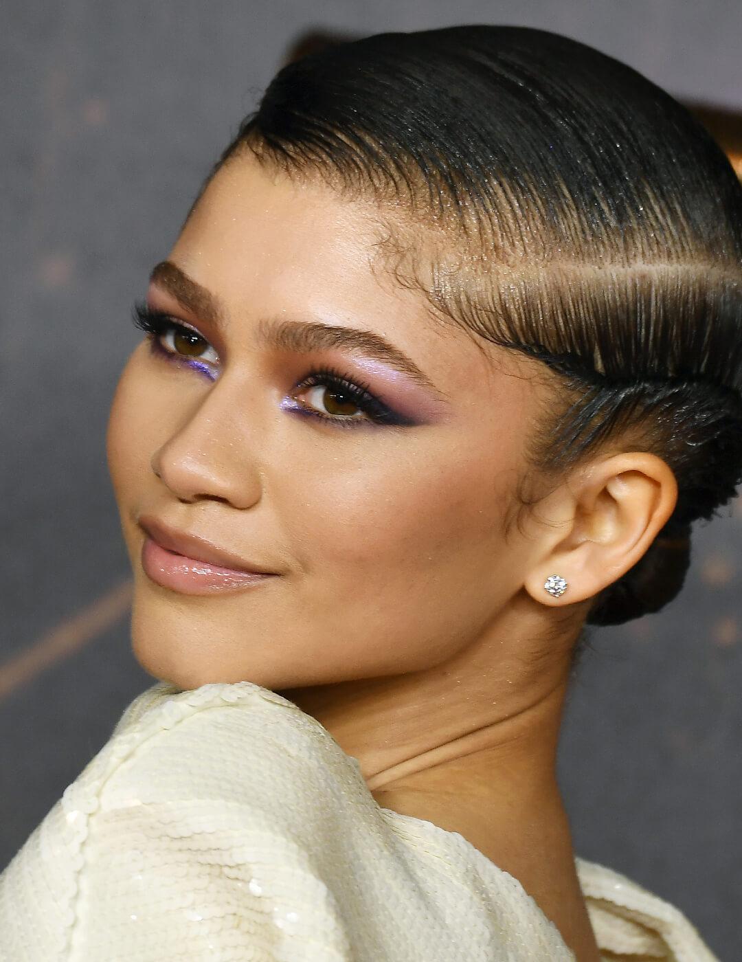 Zendaya rocking a bold periwinkle eye makeup look and white sequined dress Mobile