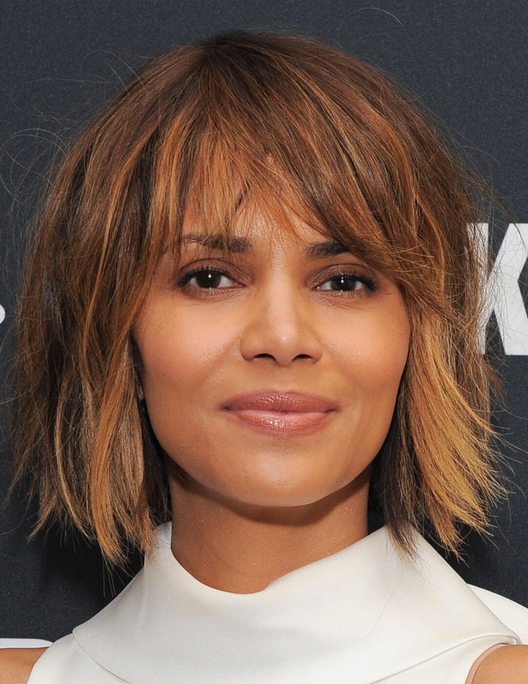 A photo of Halle Berry with a voluminous shag wearing a white sleeveless turtleneck top Desktop