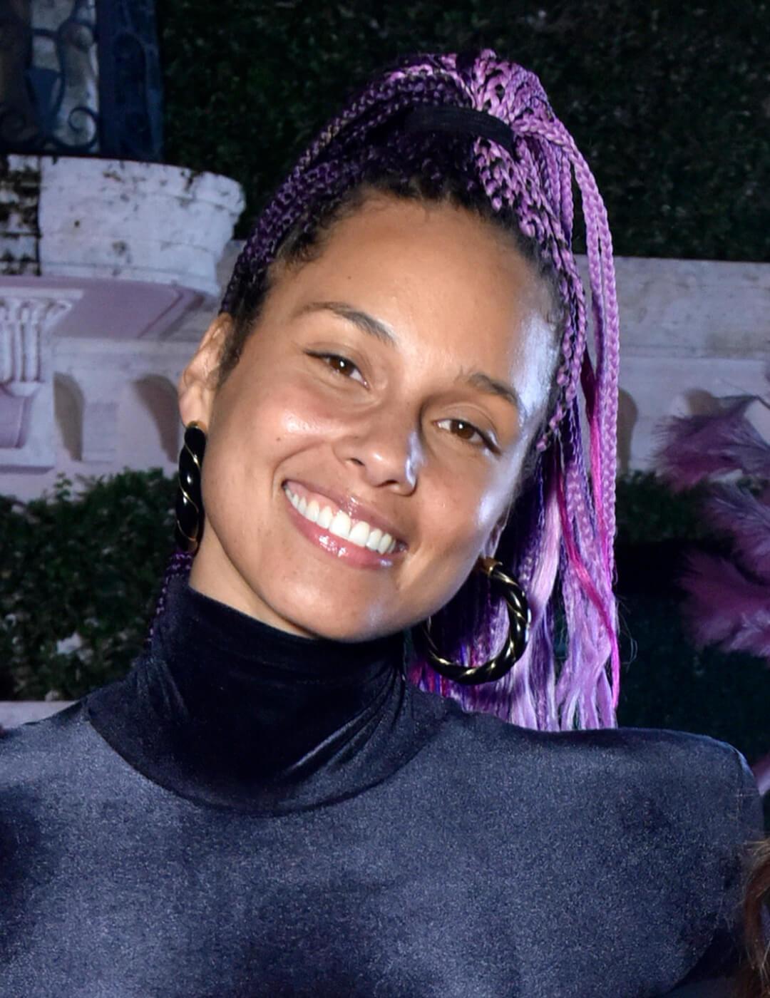 Smiling Alicia Keys rocking a purple braided high ponytail hairstyle Mobile