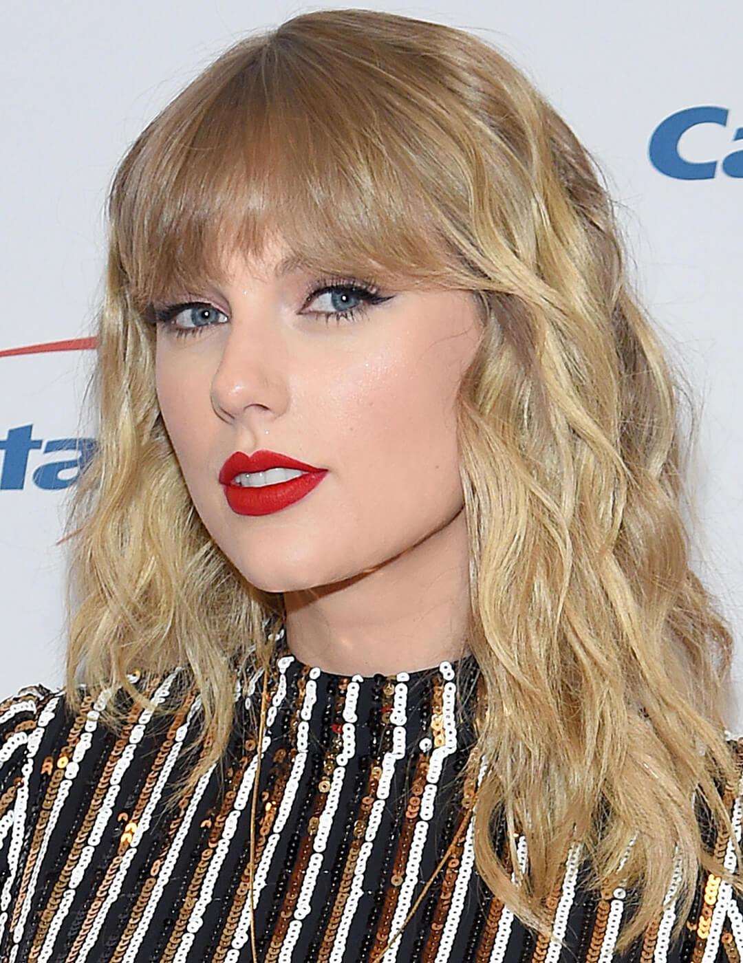 A photo of Taylor Swift with a shag cut hairstyle with bold red lips and wearing a sequin dress Mobile