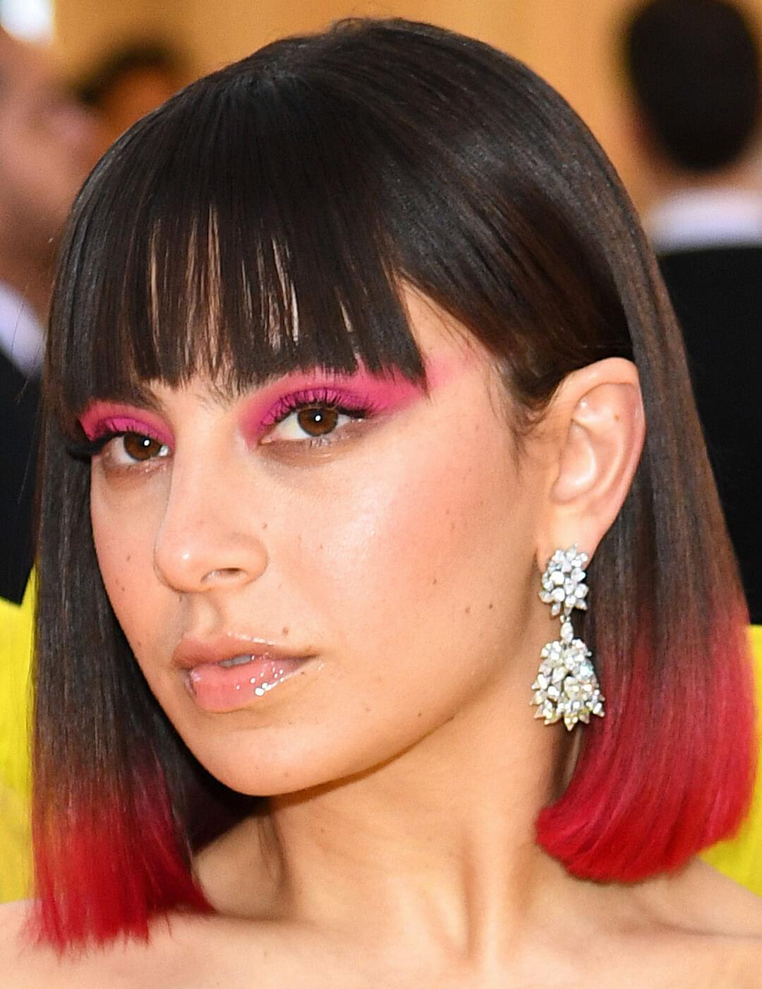 An image of Charli XCX showing her red-dyed tip hair together with her pink, smudgy look eyeliner Desktop