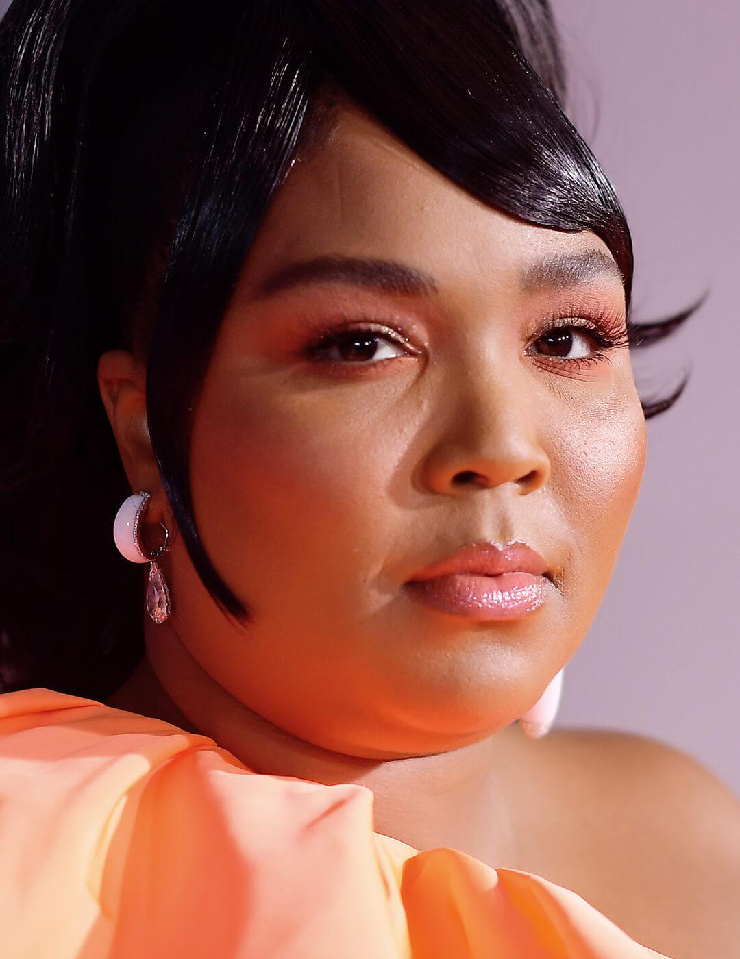 Lizzo rocking an orange eye makeup look and dress Mobile