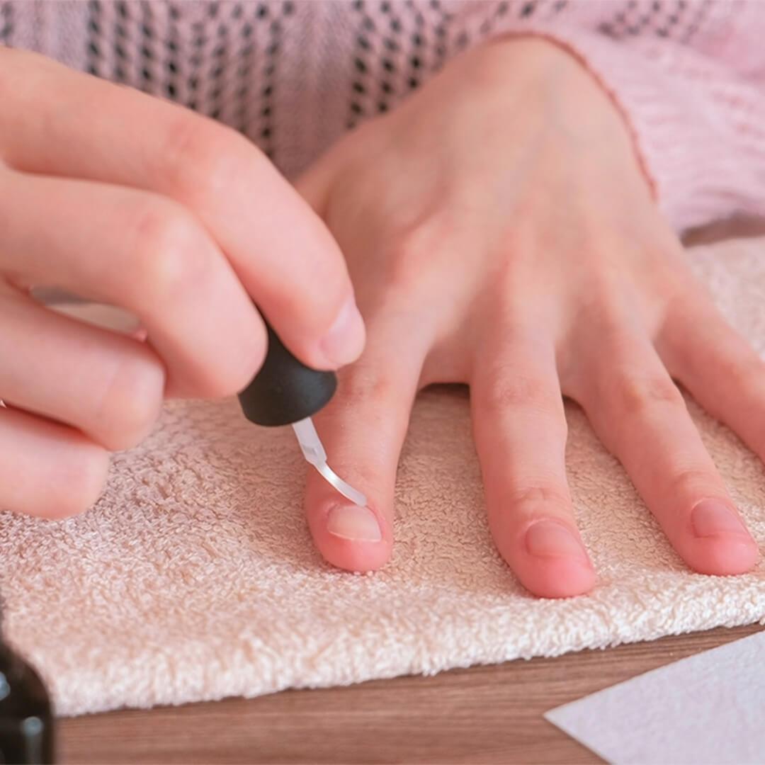 Close-up image of woman's hands putting nail oil on her nail Desktop