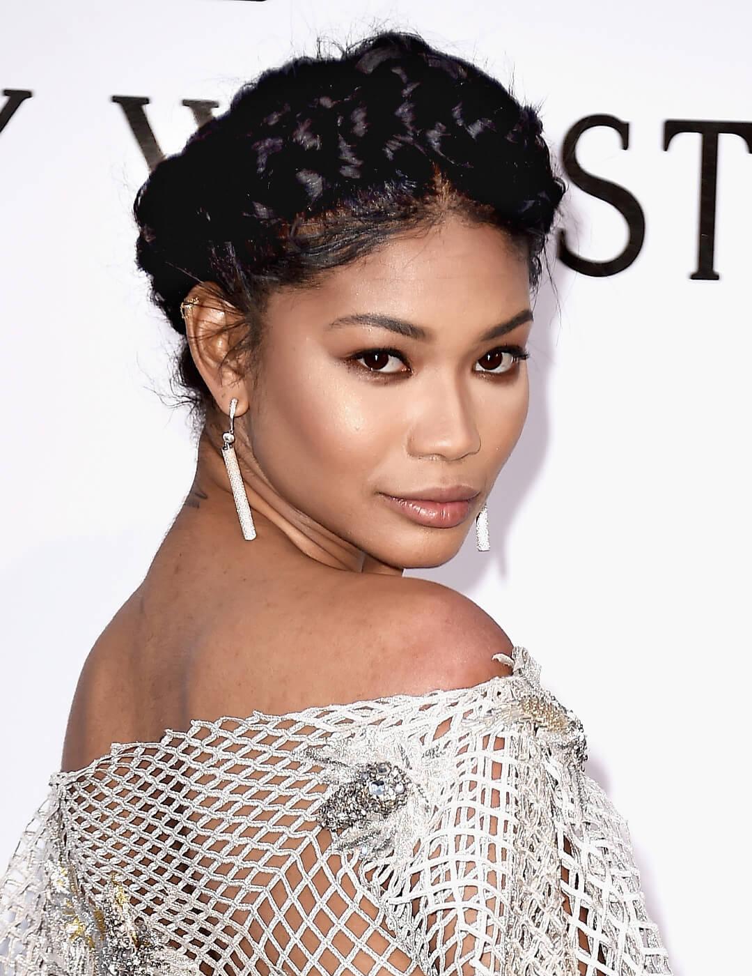 Close-up of Chanel Iman rocking a sultry makeup look, crown braids hairstyle, and a metallic fishnet dress embellished with rhinestones Mobile