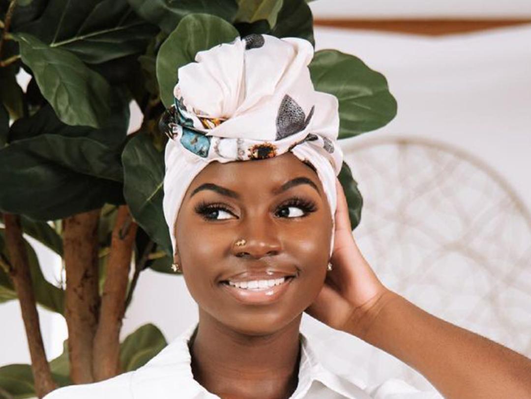 A photo of a model wearing a white collared shirt and a white bonnet with prints Desktop