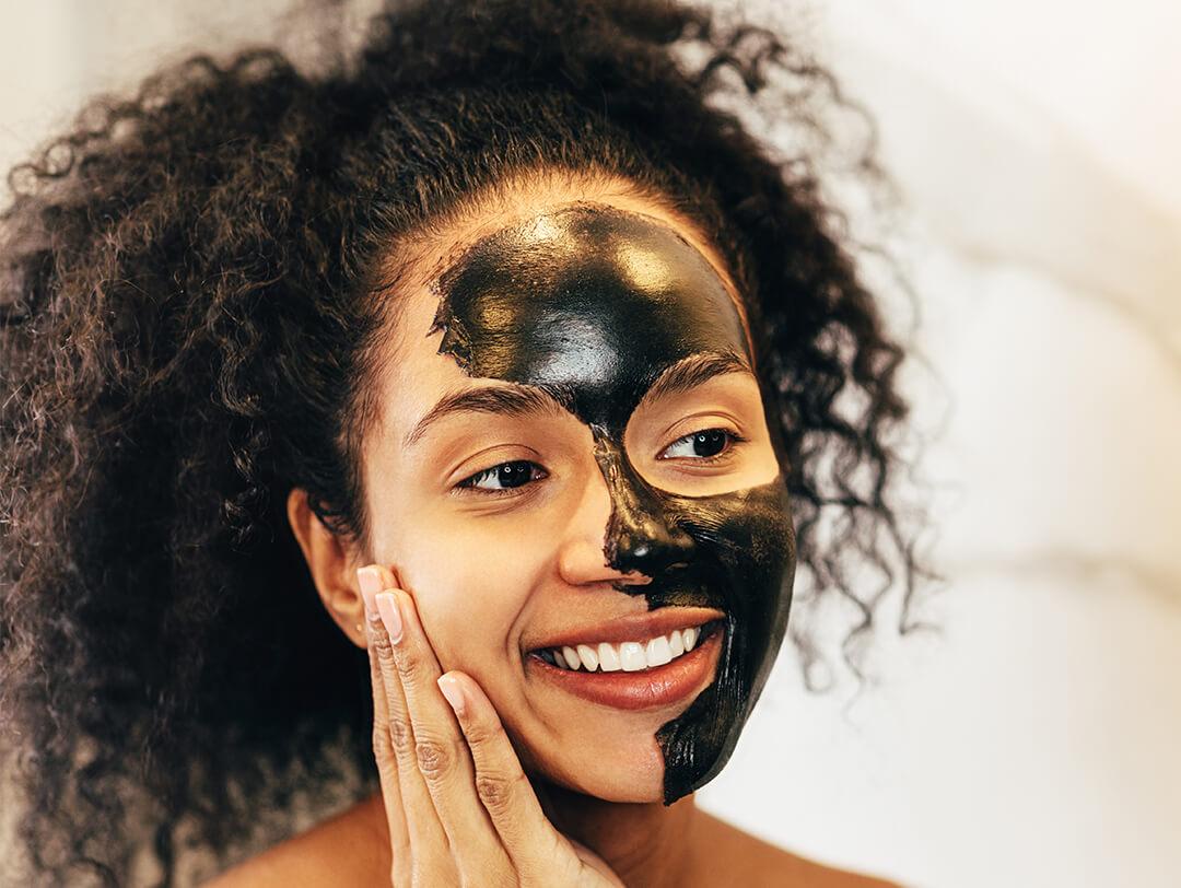 Smiling woman with charcoal mask on her face Desktop