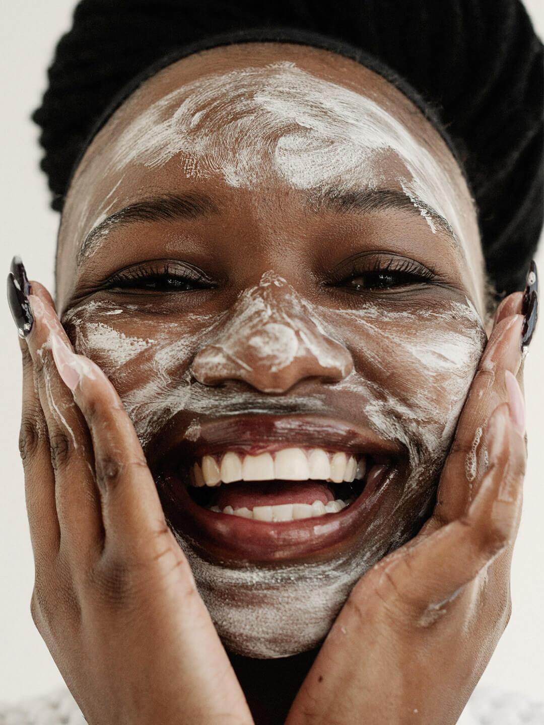 Close-up of a smiling black woman with face mask on Desktop