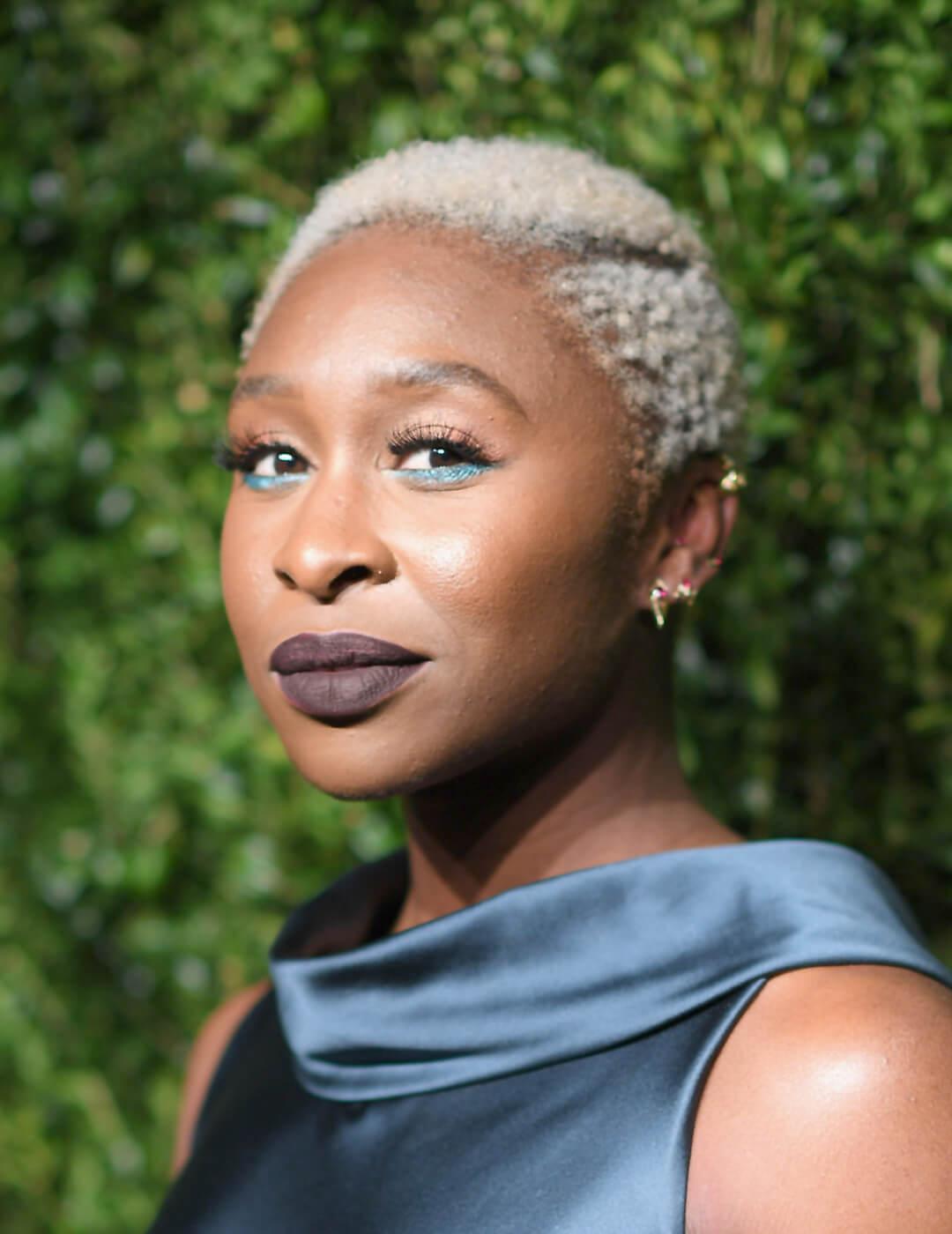 Cynthia Erivo rocking her platinum hair in a dark blue satin dress Desktop