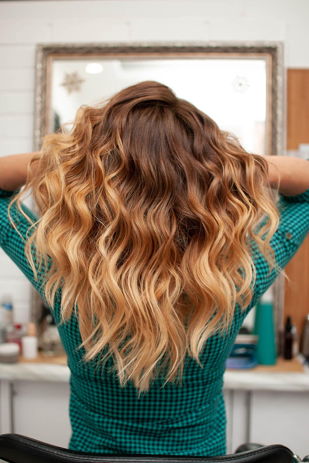 A photo of a model's back with ombre hair wearing a green blouse Desktop