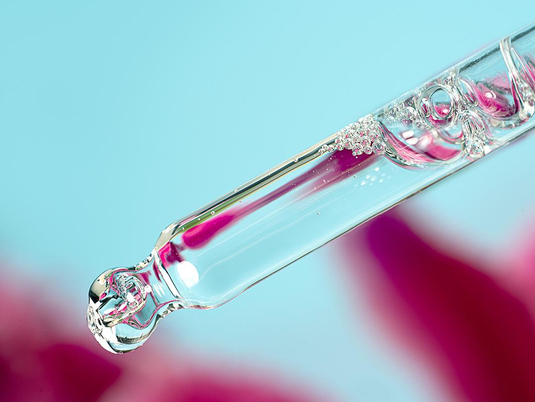 A photo of a dropper with a clear cosmetic liquid in it Desktop