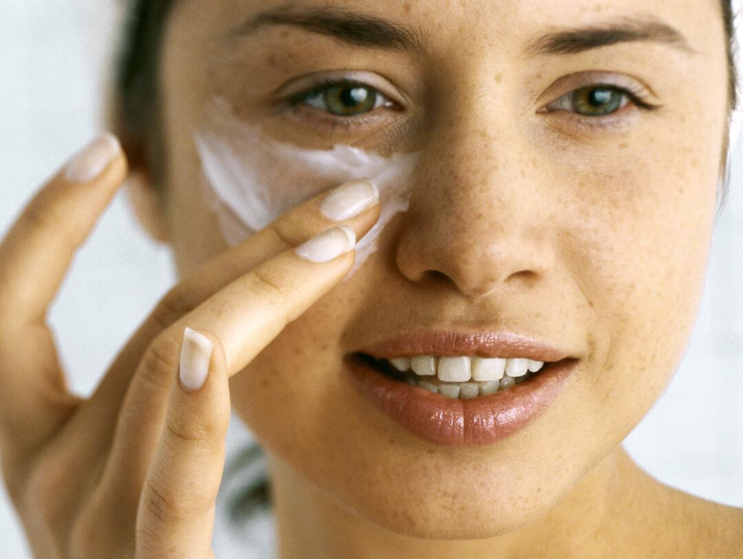 A photo of a woman putting a moisturizer underneath the eye Desktop