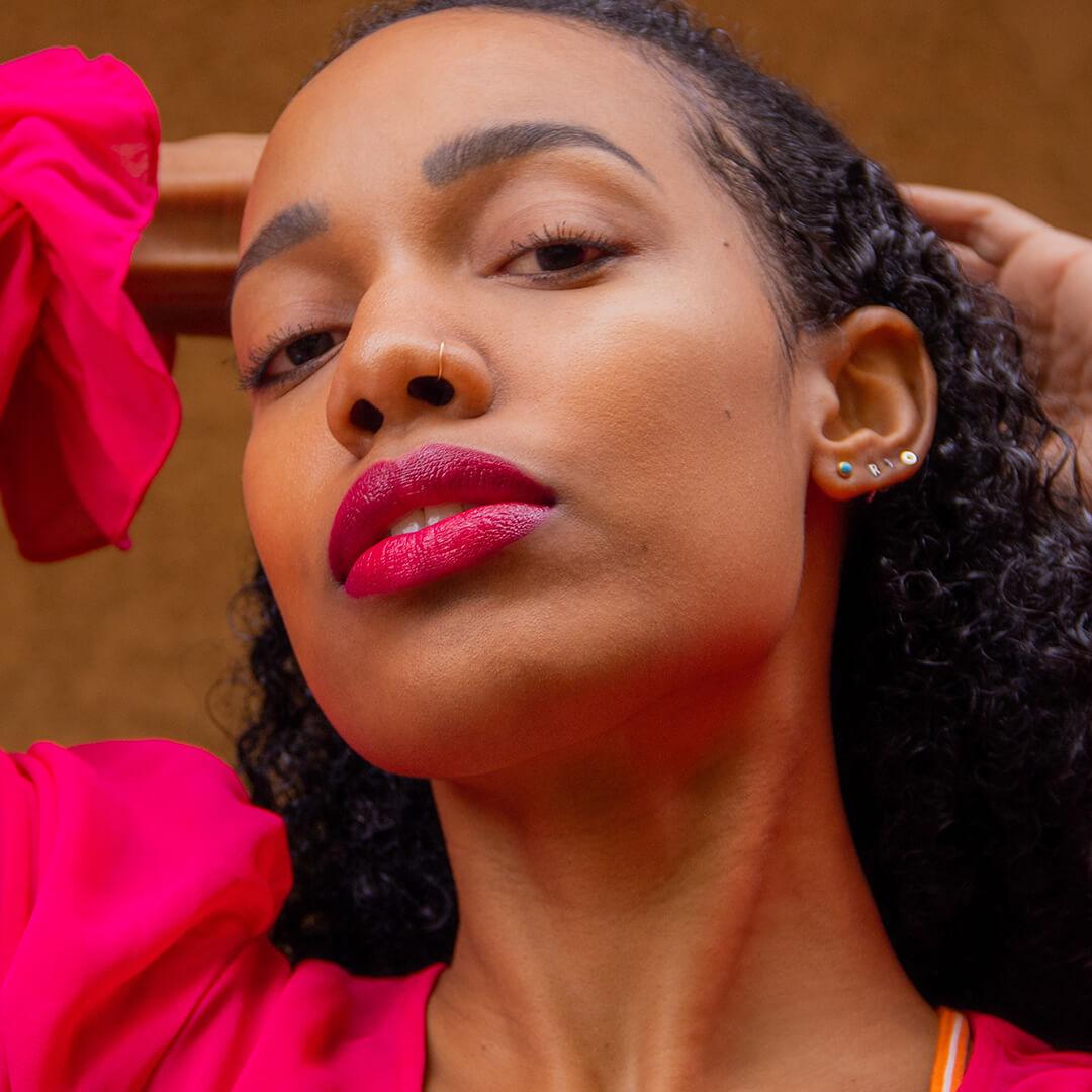 Close-up image of Bianca Alexa posing in a fuchsia outfit paired with a fuchsia lip look Desktop