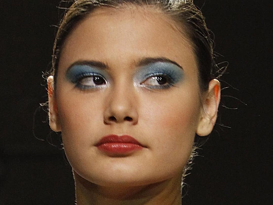 Close-up of a model wearing blue eyeshadow makeup and red lips Desktop