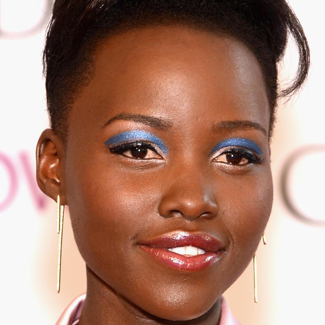 Close-up image of Lupita Nyong'o rocking a sharp and shimmery white and blue eyeshadow look Desktop