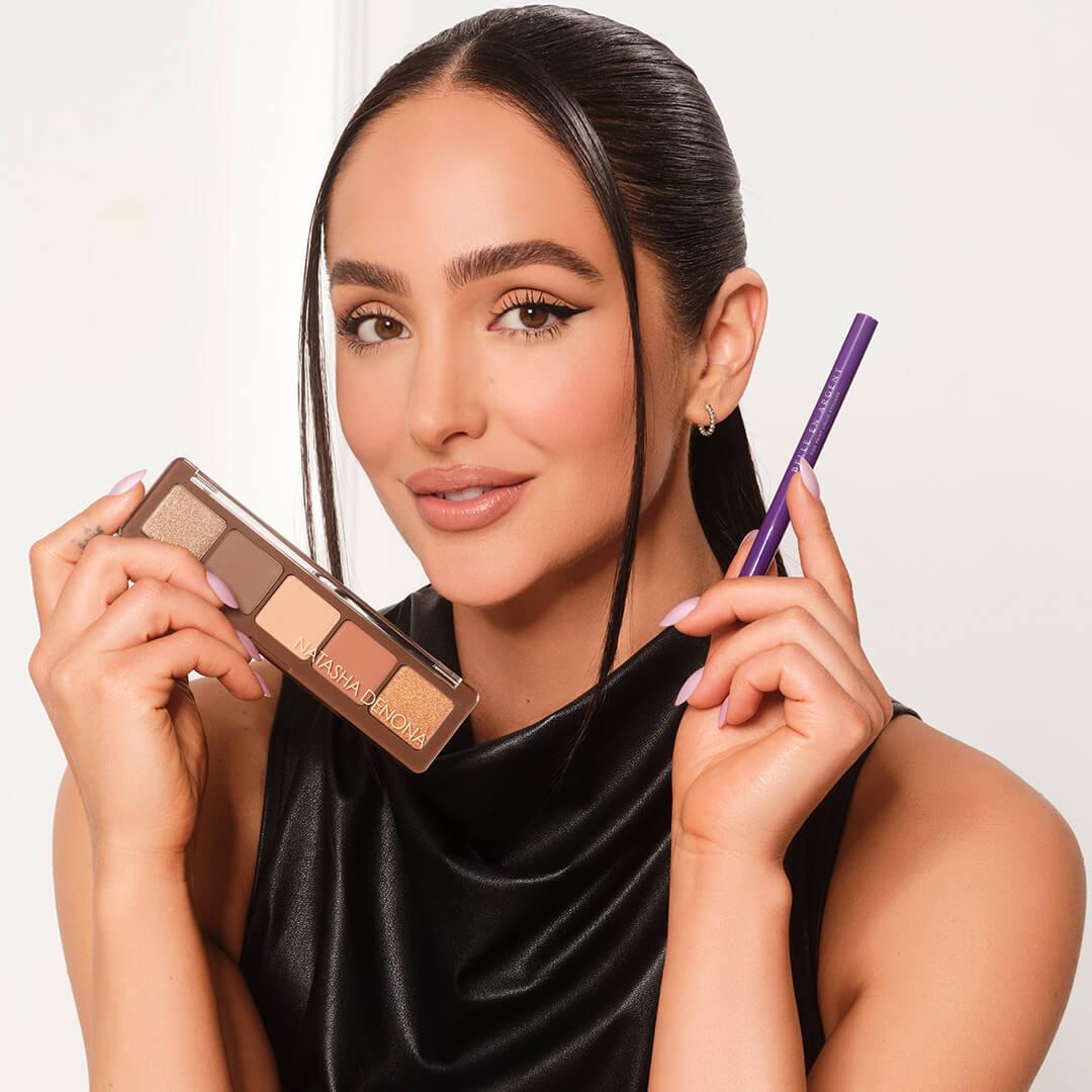 Ash K Holm holding the NATASHA DENONA Alloy Eyeshadow Palette and BELLE EN ARGENT Fine Print Liquid Liner in Black Mobile