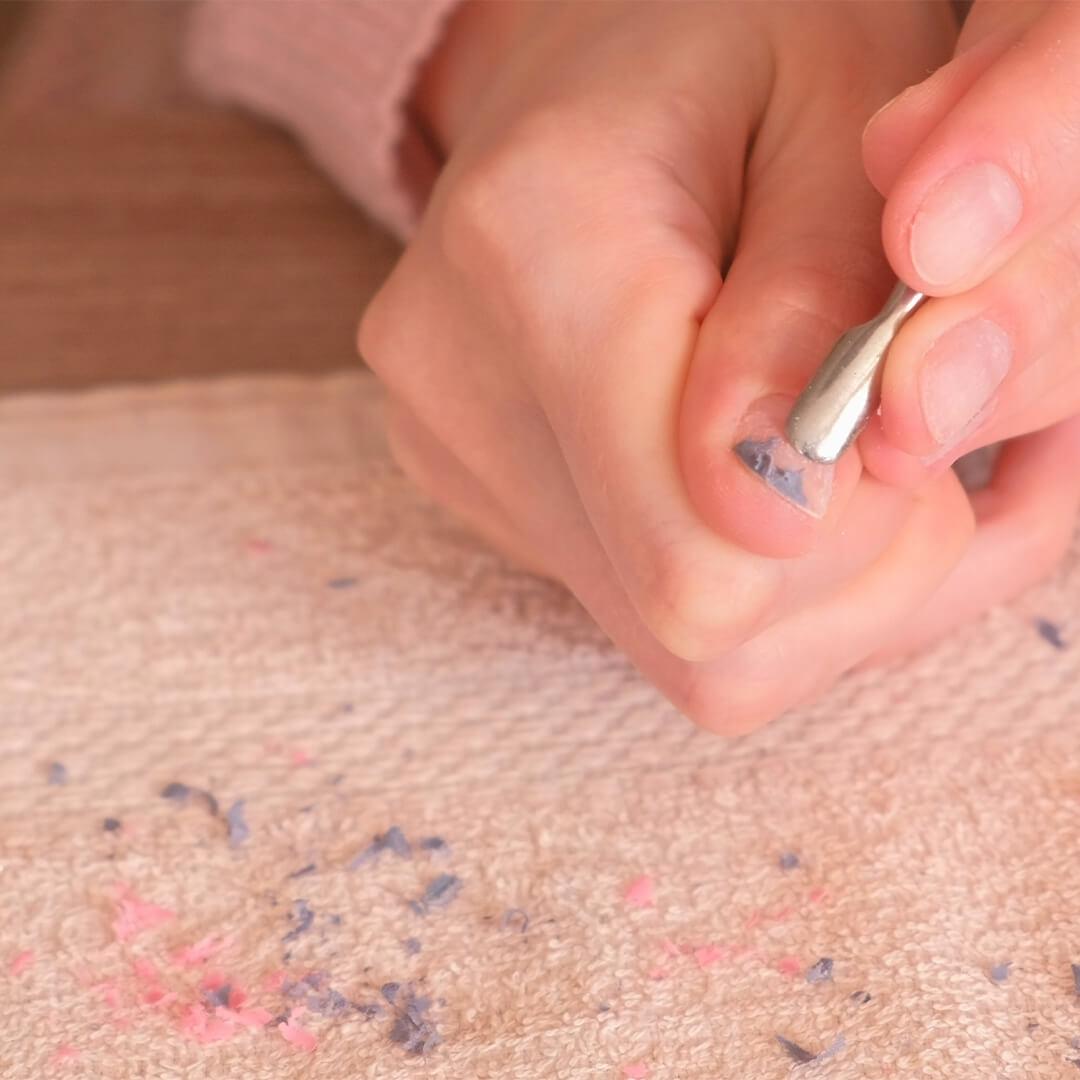 Close-up image of a woman's hands using a cuticle pusher to remove nail polish Desktop