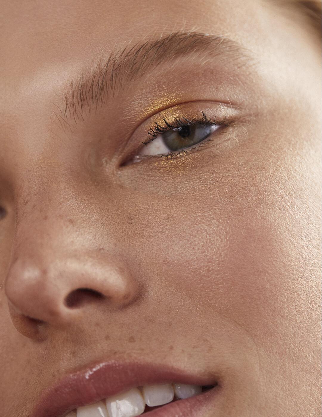 Close-up of a model's gold eyeshadow look Desktop