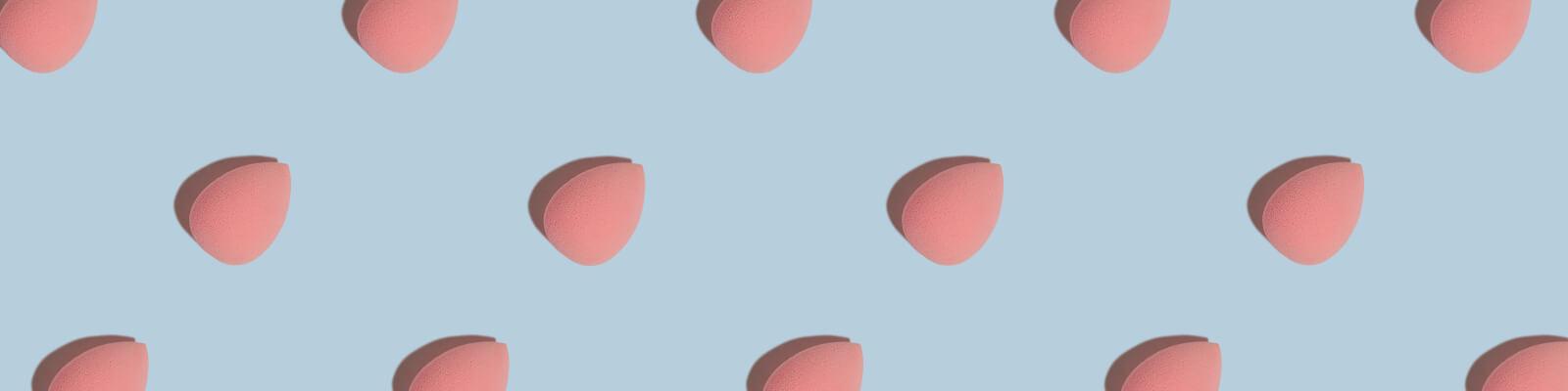 An image of pink makeup sponges beauty blenders neatly arranged on a blue surface Desktop