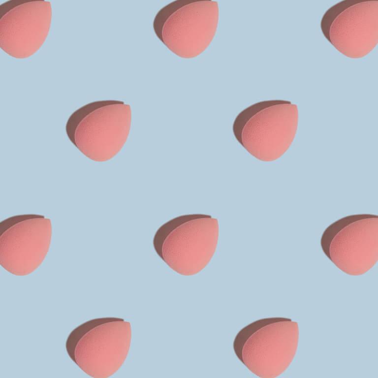 An image of pink makeup sponges beauty blenders neatly arranged on a blue surface Mobile