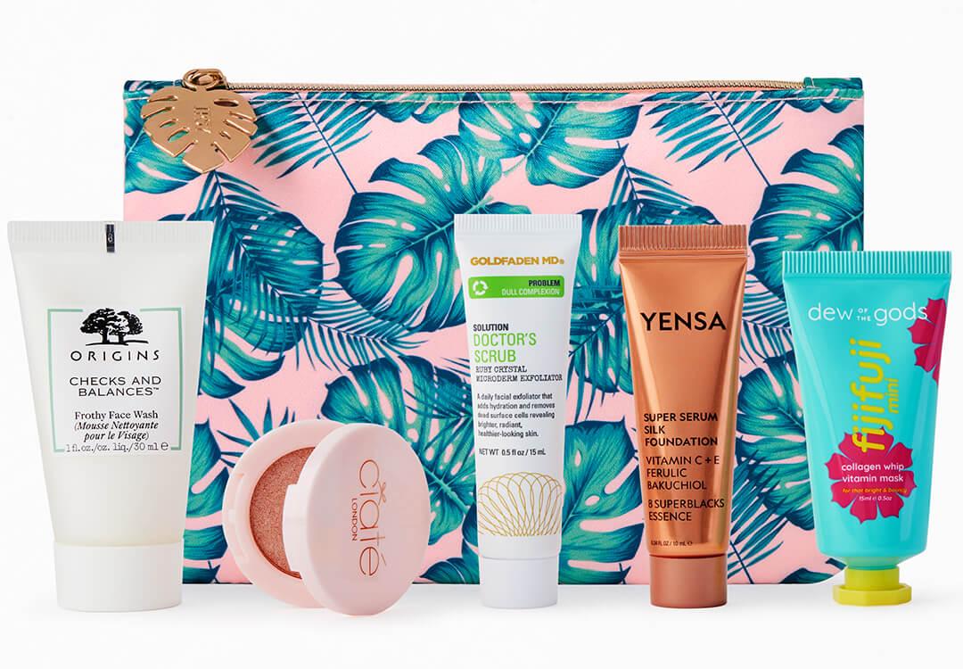 Beauty products from various brands arranged in front of IPSY palm print Glam Bag Mobile