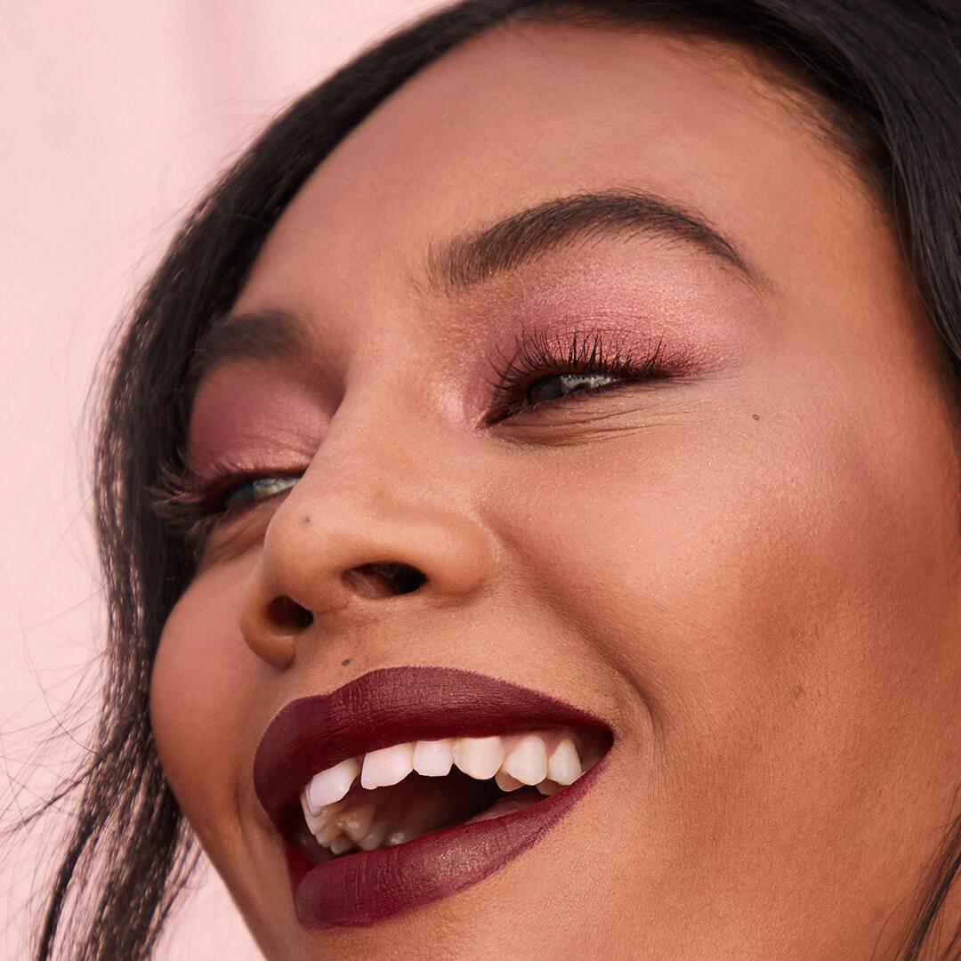 An image of a model wearing a red smoky eye and red lipstick. Mobile