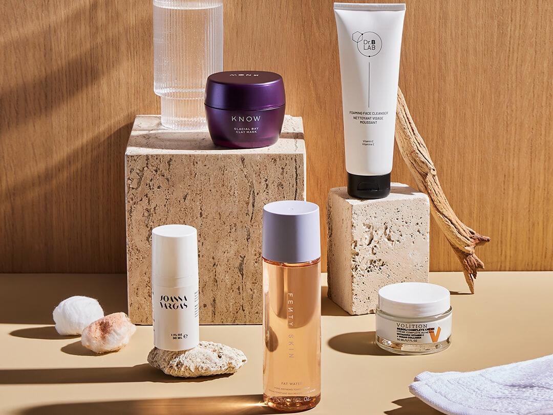 Skincare products from various brands on concrete blogs against wooden background Desktop
