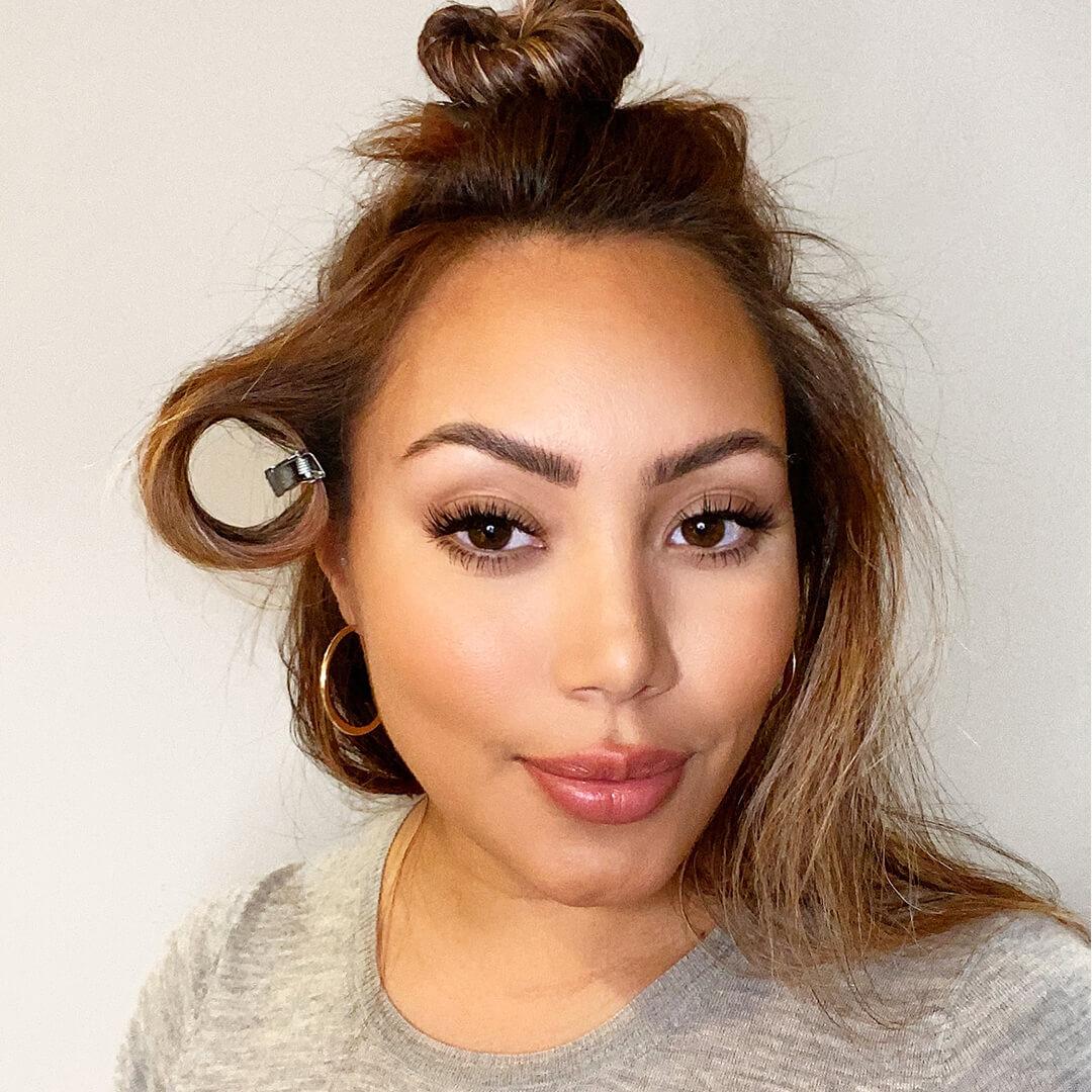 Close-up image of Cynthia Alvarez with her hair in a top know and a hair section pinned Desktop