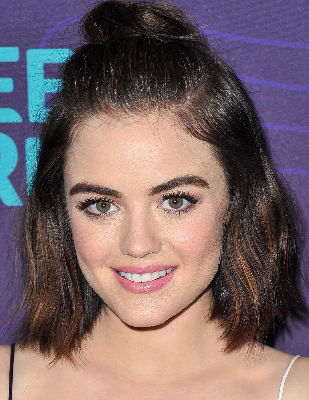 A photo of Lucy Hale with a tiny top knot hairstyle Mobile