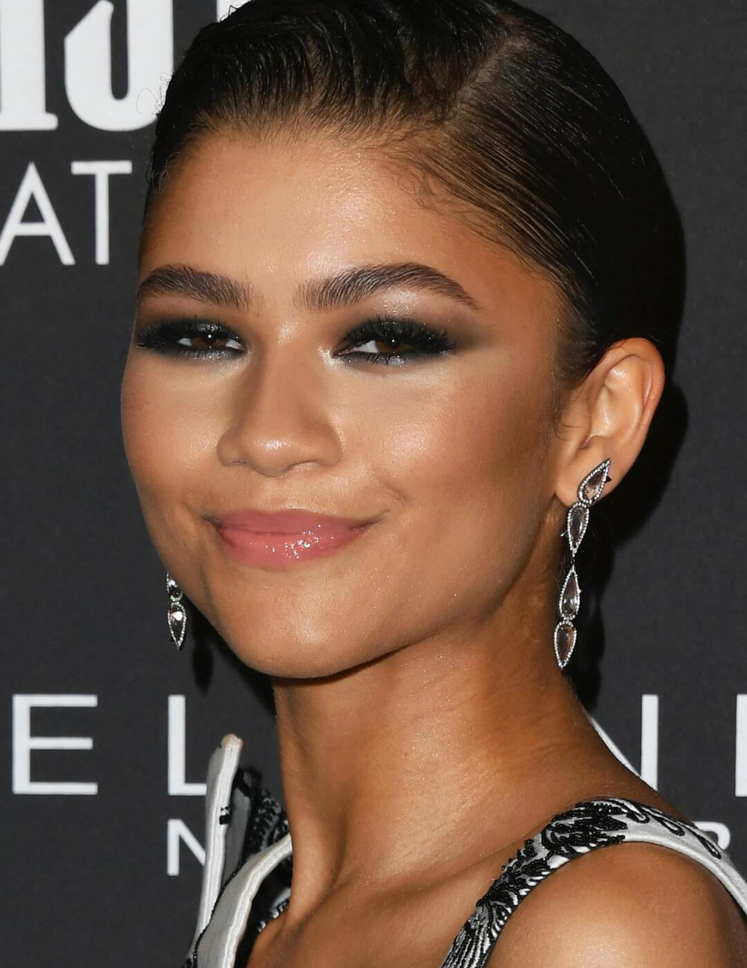 Zendaya smirking and rocking a dark, metallic smoky eye makeup look Desktop