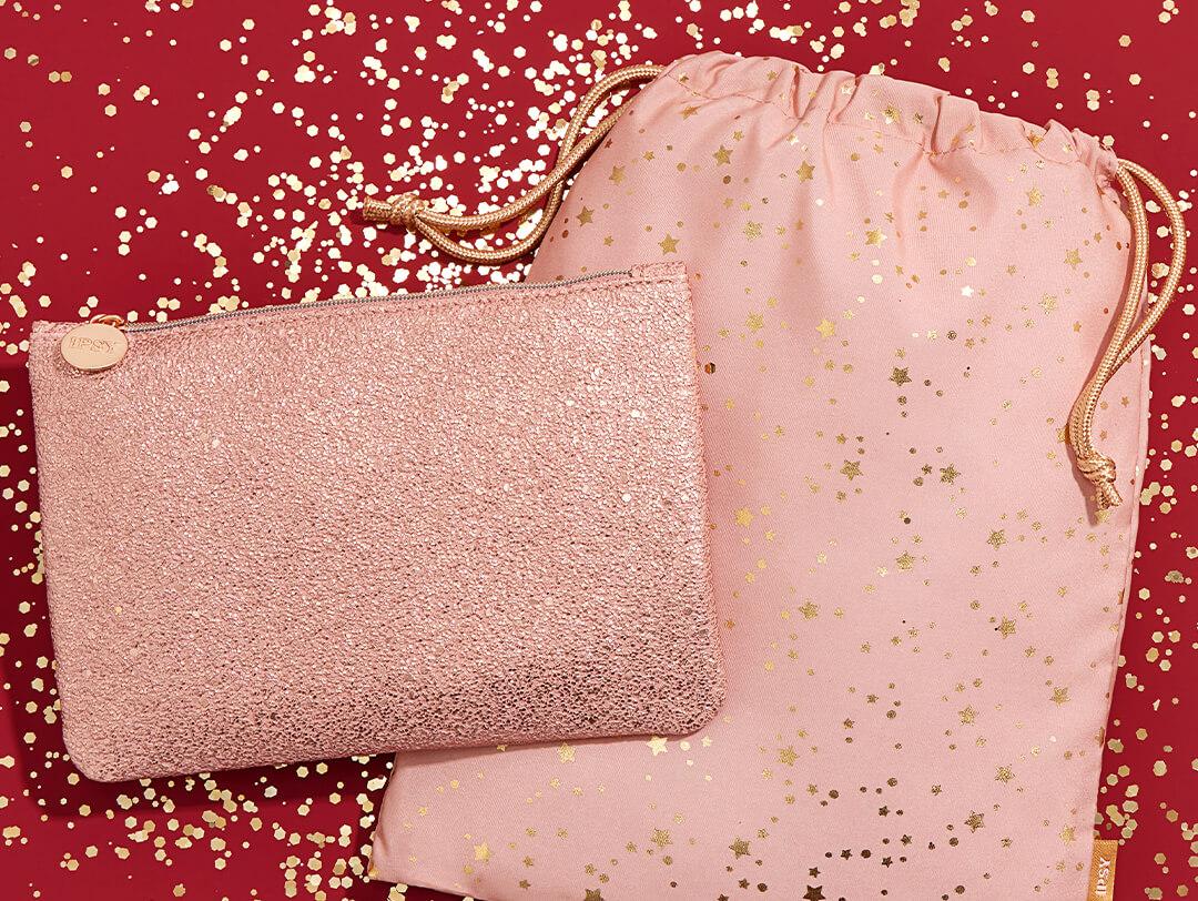 January 2021 IPSY Glam Bag and Glam Bag Plus on red surface with gold sequins and glitter Desktop