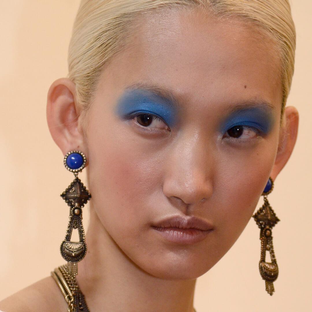 Close-up image of a model rocking a matte blue eyeshadow look Mobile