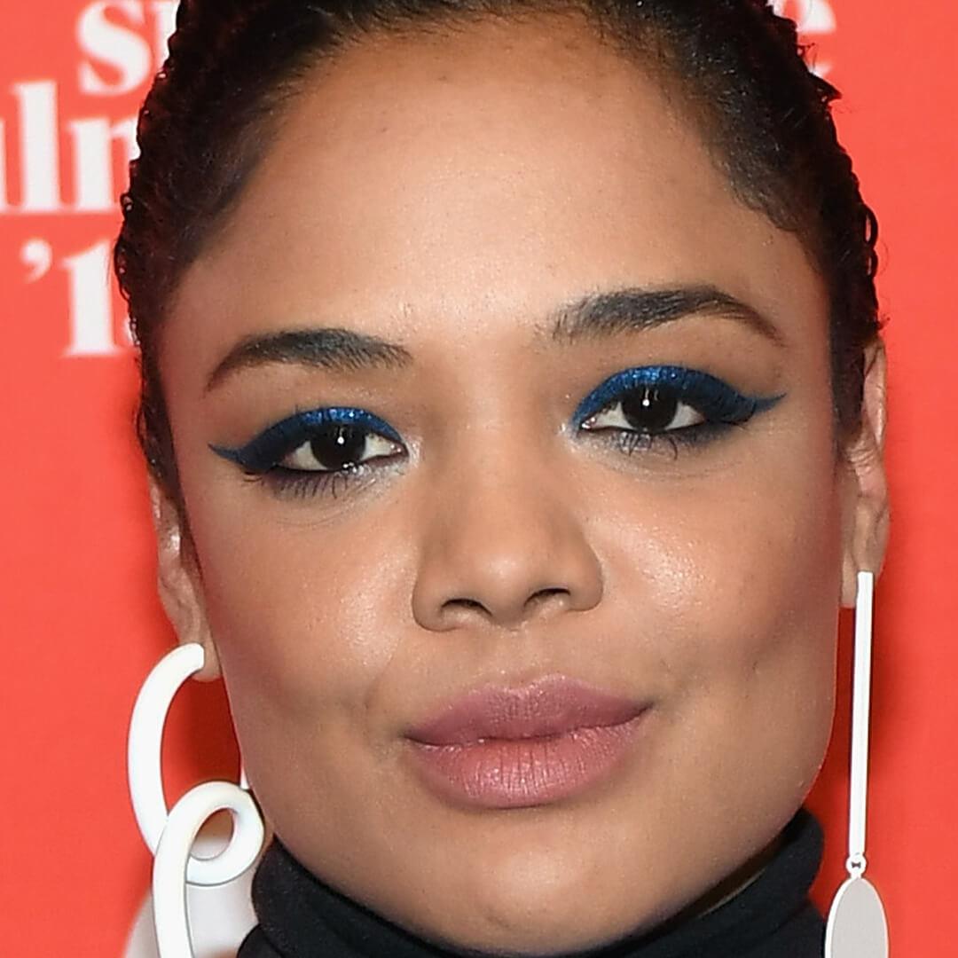 Close-up image of Tessa Thompson rocking a glittery blue eyeshadow look paired with nude lipstick Desktop