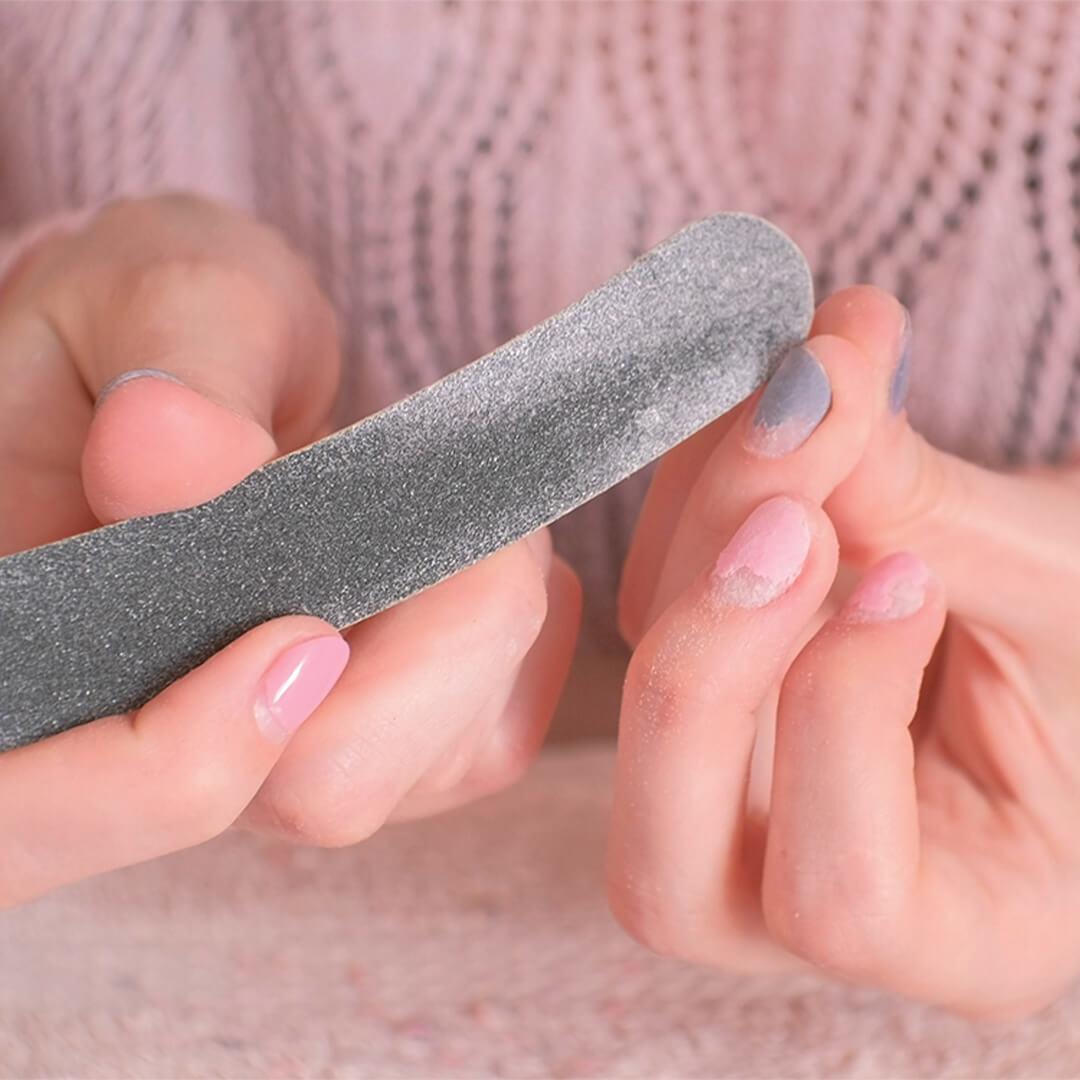 Close-up image of a woman's hands filing her nails Mobile