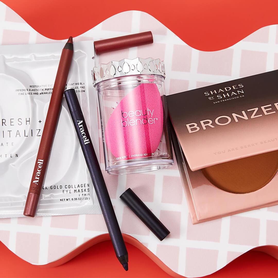 Flat-lay image of makeup and skincare products and tools on pink and white tile background Desktop