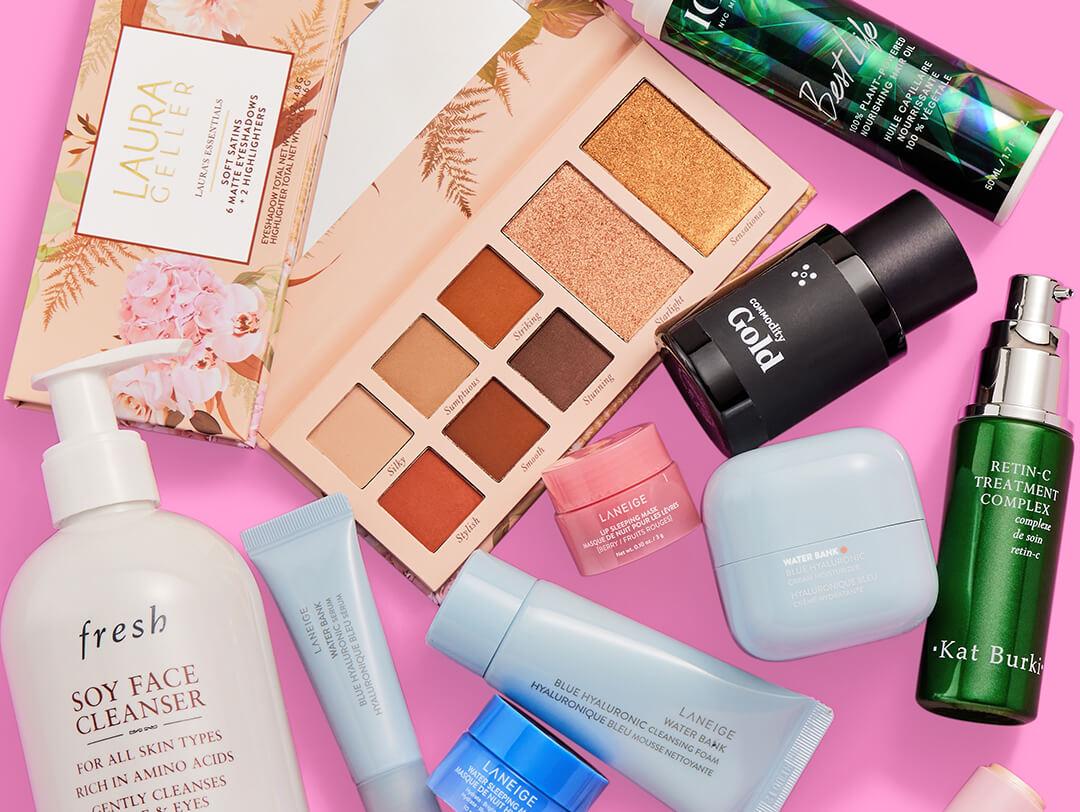 Beauty and makeup products and tools from various brands scattered on pink background Desktop