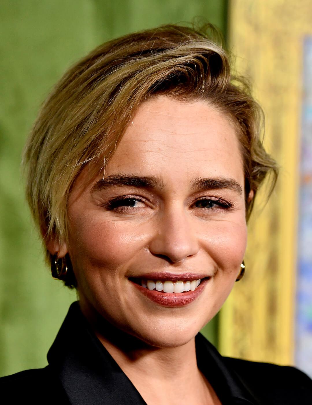 Close-up of Emilia Clarke smiling and rocking a neutral makeup look and long pixie cut hairstyle Desktop
