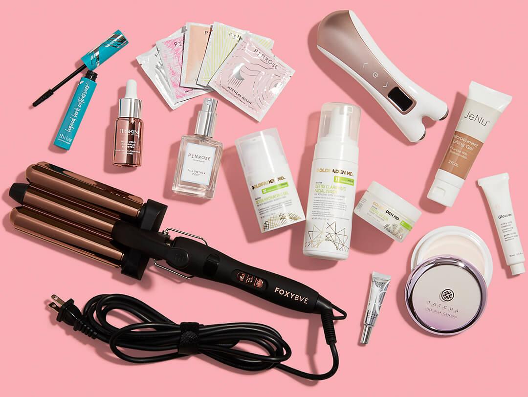 Makeup, skincare, and hair care products and tools on pink background Desktop