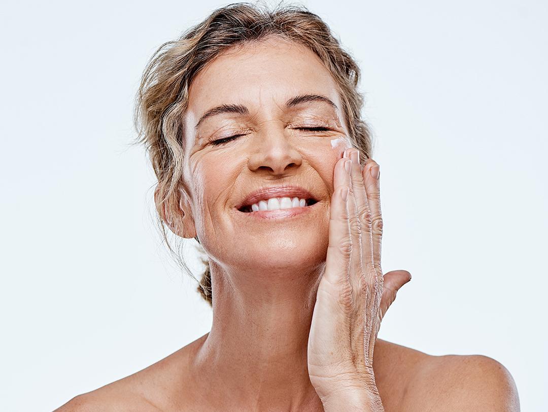 An image of a mature woman applying moisturizer on her face Desktop