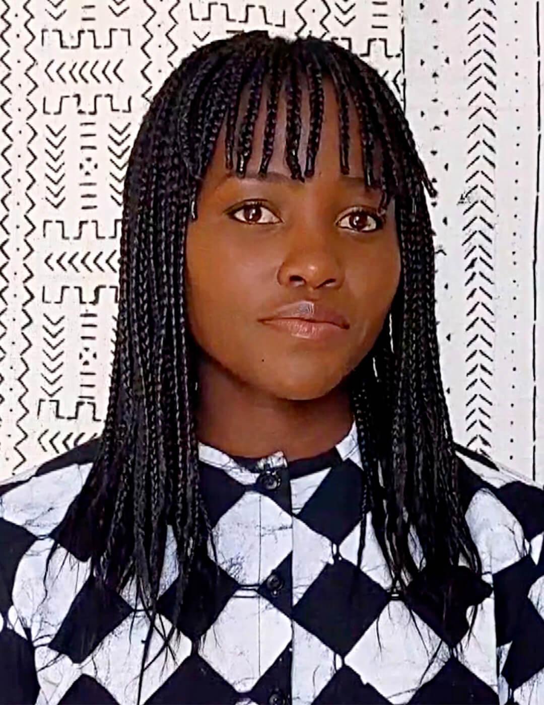 Lupita Nyong'o rocking a braided hairstyle and black and white shirt Desktop