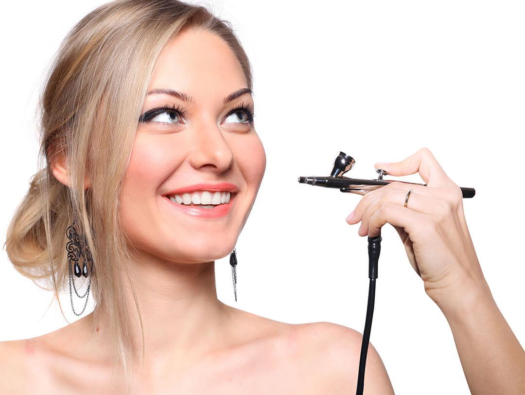 Photo of a model smiling with an airbrush near her face Desktop