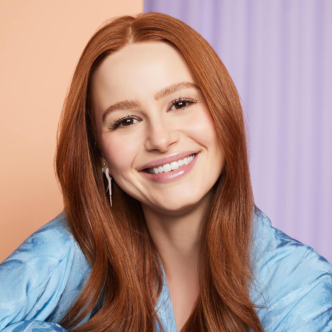 Close-up of a smiling Madelaine Petsch in a satin blue blouse Mobile
