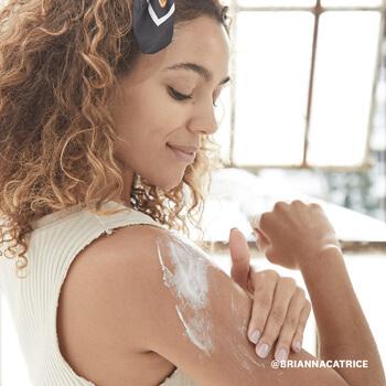 A model applies a body lotion after using an exfoliating body scrub. Mobile