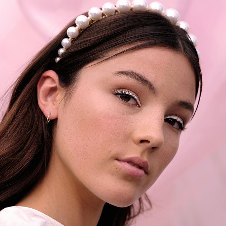 An image of a model wearing a white eyeliner look and a pearl-embellished headband Desktop