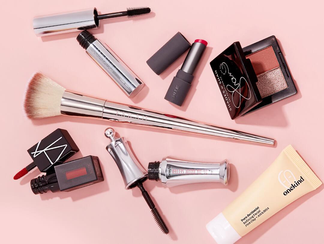 Image of skincare and makeup products and tools scattered on pink background Desktop