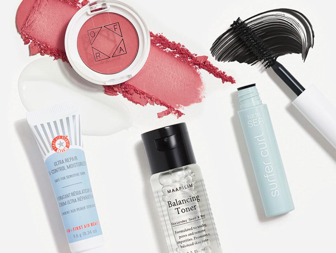 Makeup and skincare products from various brands in the December 2021 IPSY Glam Bag swatched on white background Desktop