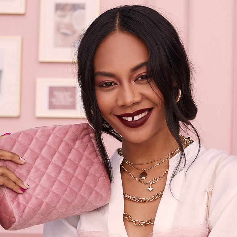 An image of a model wearing hoop earrings and dark mauve lipstick showing her loose braids Mobile