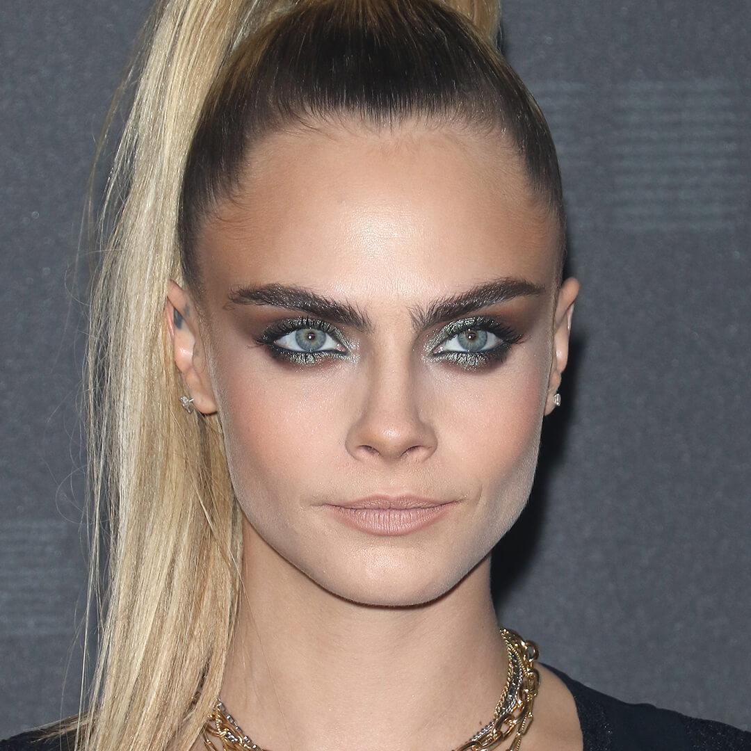 Close-up of Cara Delevingne rocking a high ponytail hairstyle and a grunge makeup look Desktop