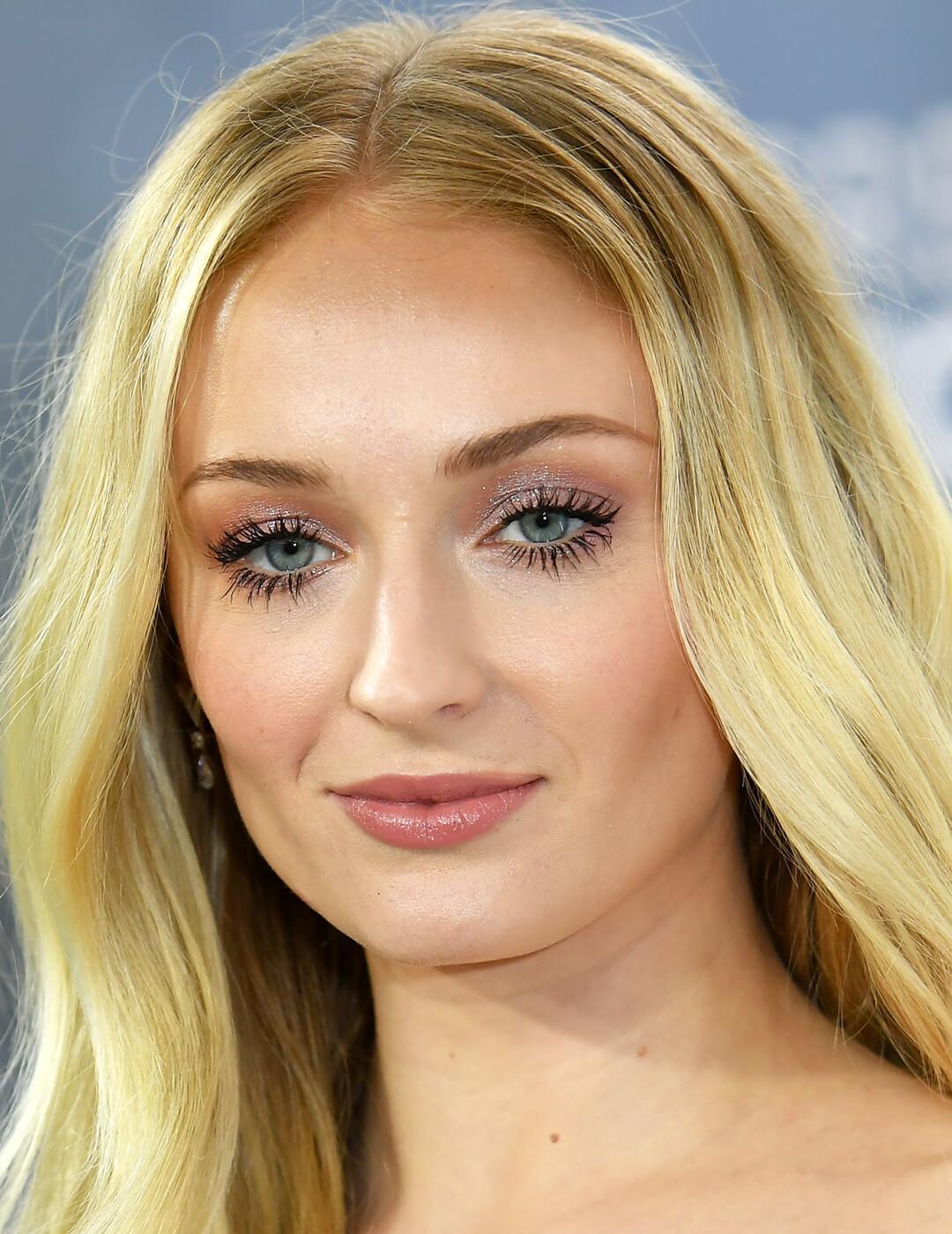 Sophie Turner rocking a shimmery mauve eyeshadow makeup look and bold fluttery lashes on the red carpet Desktop